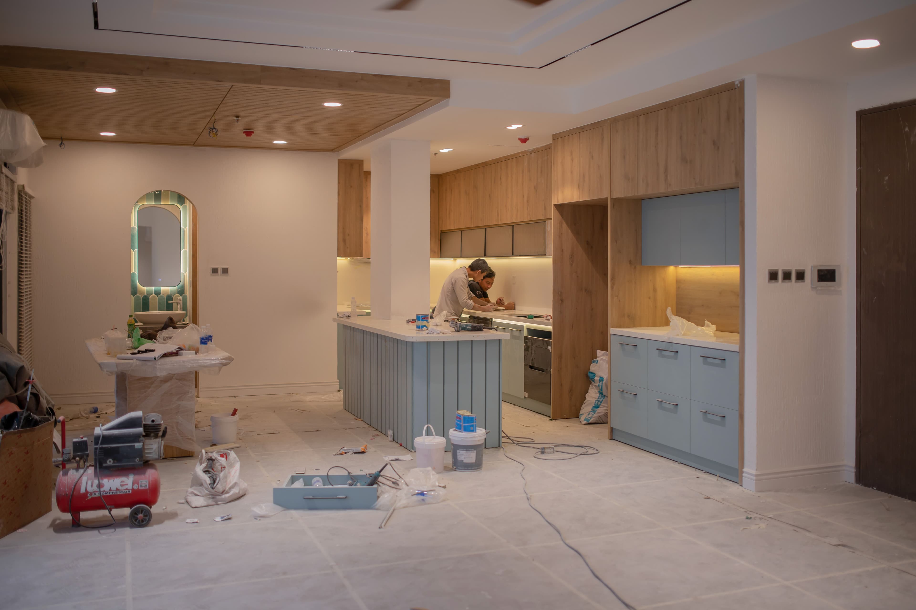 Worker renovating a kitchen with tools and materials on site
