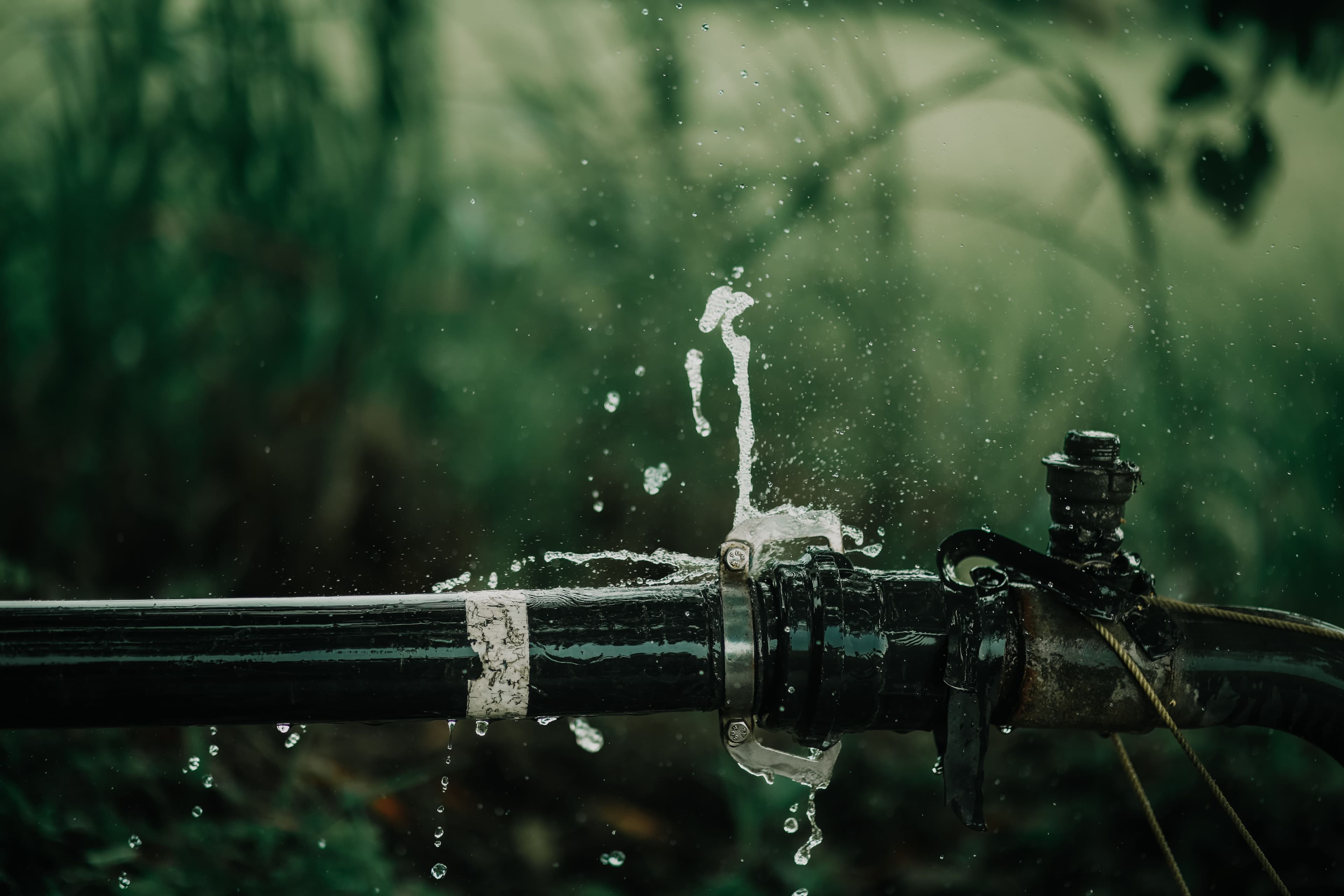 Water spraying forcefully from a burst pipe joint